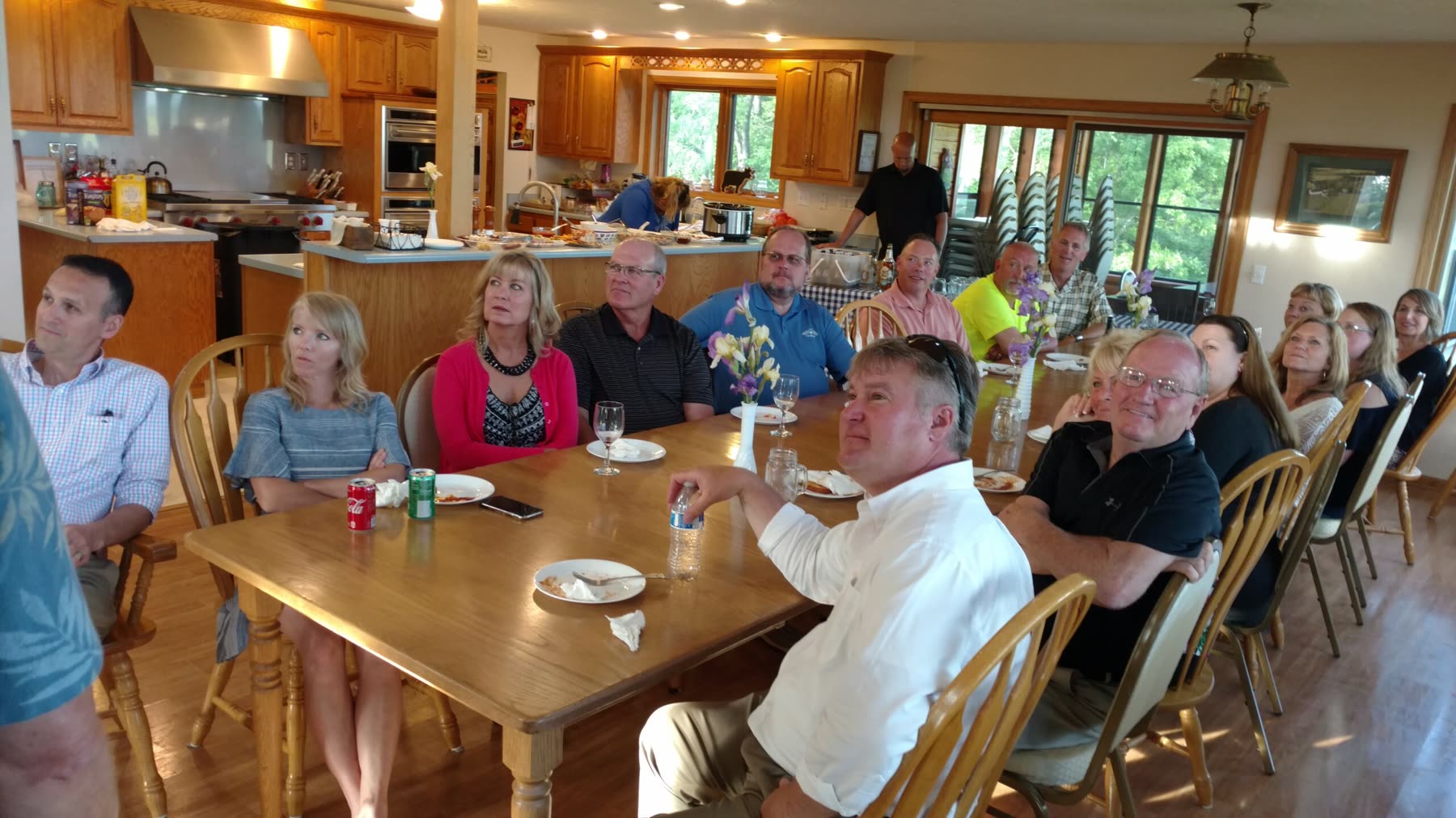 Guests seated around the farmhouse table for a farm-to-table dinner